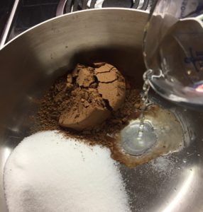 in pot whisk together sugar, cocoa & salt, add hot water